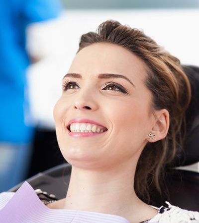 woman smiling in dental chair with metal-free restorations in Center