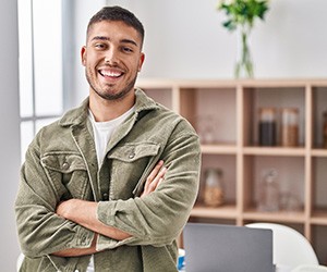 Man with green jacket smiling at home