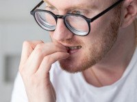 Closeup of man biting his nails