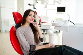 Woman smiling while waiting for her crown in patient chair