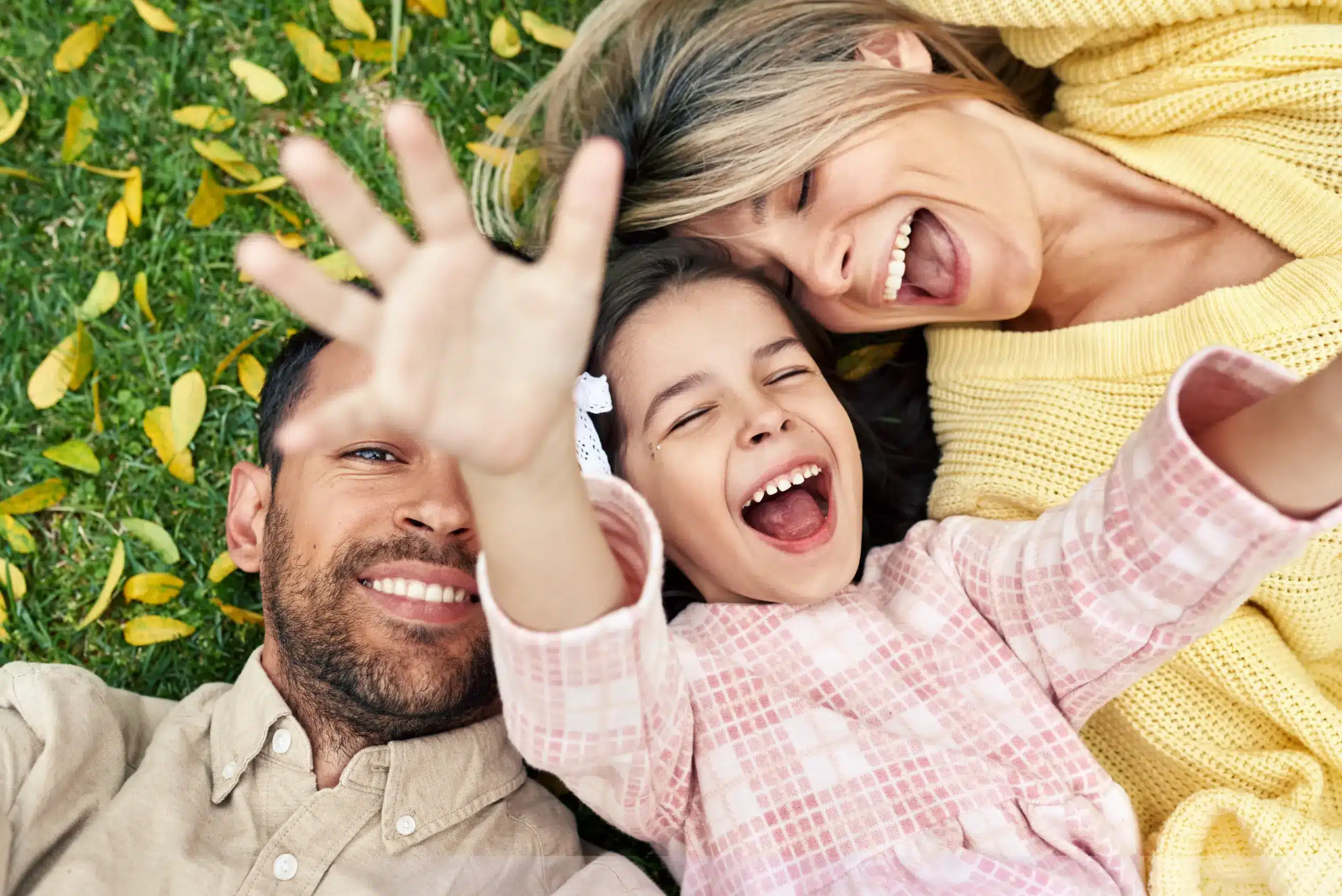 Laughing family lying together on the grass