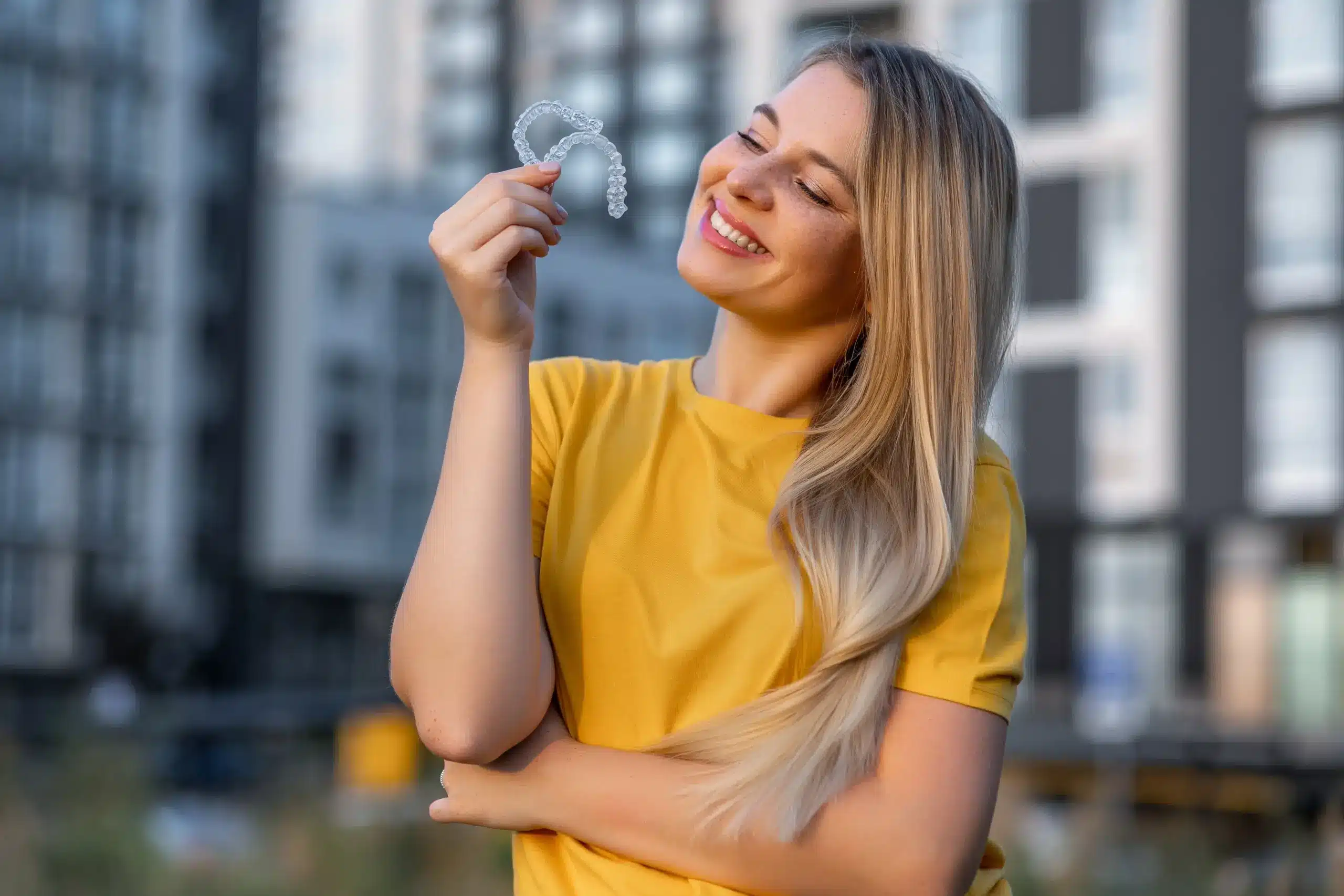 Woman holding clear aligner showing Clear Aligners in Center TX